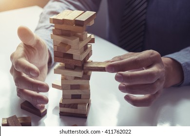 business man placing wooden block on a tower concept risk control, Planning and strategy in business.vintage tone