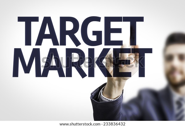 Business man pointing to black board with text: Target\
Market 