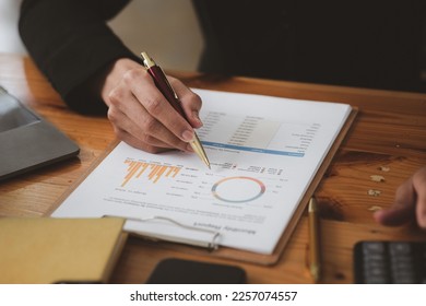 Business man pointing to a pie chart document showing company financial information, He sits in her private office, a document showing company financial information in chart form. Financial concepts - Shutterstock ID 2257074557