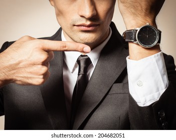 Business Man Pointing At The Time. Running Late.