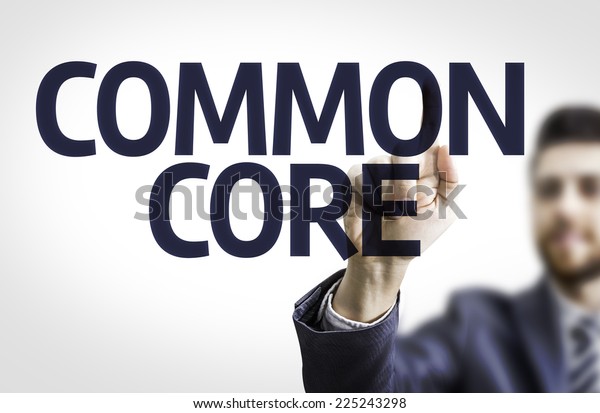 Business man pointing to transparent board with\
text: Common Core