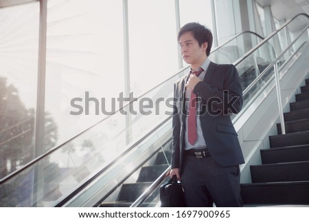 Business man portrait at the office. Casual young businessman wearing white shirt with red and black suit.
