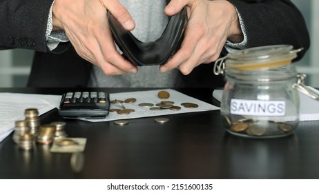 Business Man Pouring Money from his Wallet on a Desk, Trying to Saving Some Money. Economic Crisis and Financial Difficulties Concept