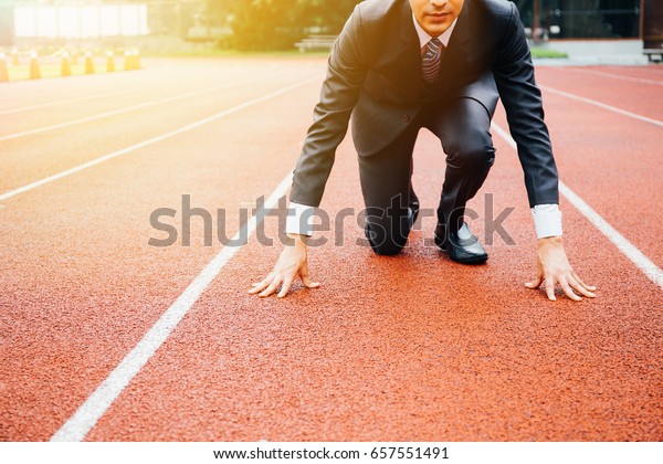 Business man preparing to run on the competition\
running track