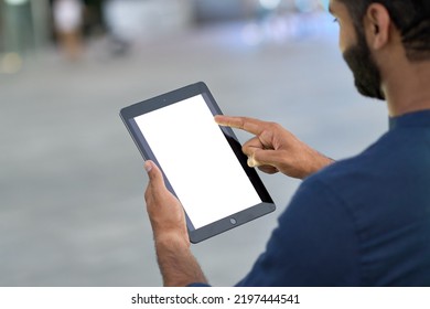 Business man professional holding digital tablet in hands using pad with white empty screen mock up template outdoors on urban city street. Mockup display for ads. Over shoulder view