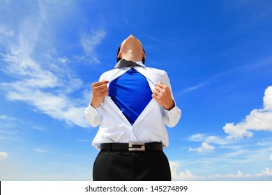 Business man pulling his t-shirt open, showing a superhero suit underneath his suit - Powered by Shutterstock