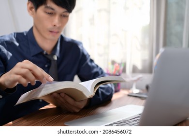 business man reading a book at his desk - Shutterstock ID 2086456072