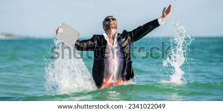 business man refreshing after working day. business vacation. business man on summer vacation. Businessman in sea holding laptop. Summer business. Freelancer on summer sea beach