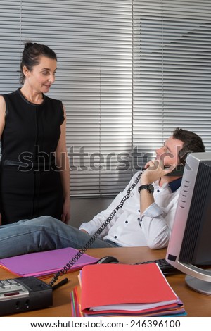 business man relaxing at office desk and talking on mobile phone
