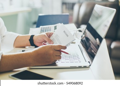 Business man review his resume on his desk, laptop computer, calculator and cup of coffee,Seleted focus. - Powered by Shutterstock