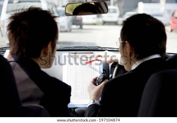 Business Man
Reviewing The Documents In The
Car