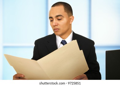 Business Man Reviewing Folder In His Modern Office