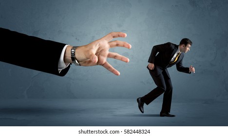 Business Man Running Away From A Huge Hand Concept On Background