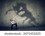 Business man scared by his monster shadow