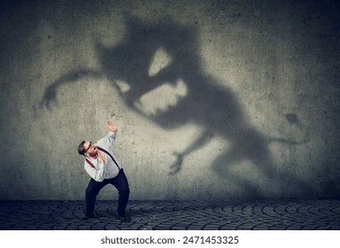 Business man scared by his monster shadow