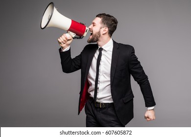 Business man screaming with a megaphone on grey background - Powered by Shutterstock