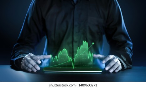 Business man showing profitable stock market holographic technology graphs in modern work background for the future. Company managers in concept planning and managing global marketing and investment. - Powered by Shutterstock