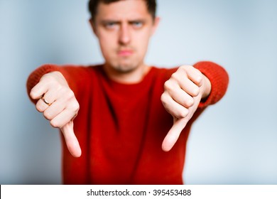 Business Man Showing A Sign Of Not Good, Thumbs Down, Isolated On A Gray Background