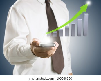 Business Man Showing Smart Phone With Growth Graph In Background