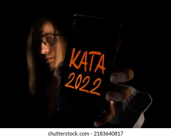 Business Man Shows The Kata Tax Law Text On The Mobile Smart Phone Screen. Direct Energy Saving Soft Lighting And Shadows Background Concept In The Isolated Studio. 2022.07.18. Hungary, Budapest