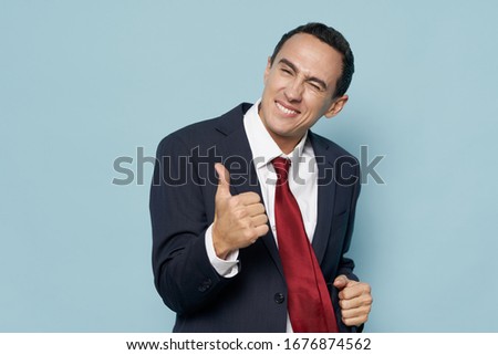 Business man shows a positive gesture with his hand and a red tie