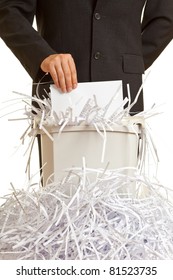 Business man shredding confidential documents at overflowing shredder