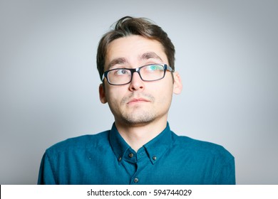 Business Man Is Shy, Wears Glasses, Isolated On A Gray Background