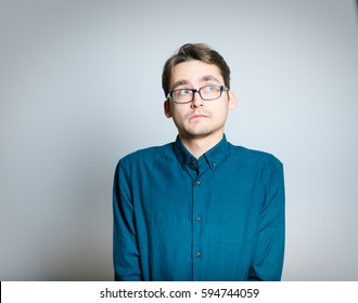 Business Man Is Shy, Wears Glasses, Isolated On A Gray Background