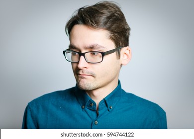 Business Man Is Shy, Wears Glasses, Isolated On A Gray Background