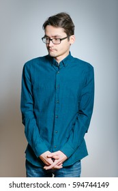 Business Man Is Shy, Wears Glasses, Isolated On A Gray Background