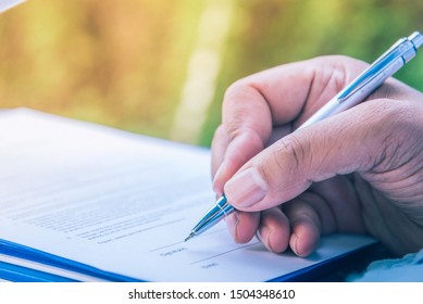 business man  signing contract  buy sell real estate contract on the table.contract compost hand with pen sign paper agreement document job or paperwork concept.