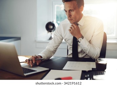 Business Man Sitting At His Desk Working On A Computer And Looking Concentrated