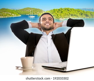 Business Man Sitting At Office Desk With Computer Thinking And Dreaming Of Summer Vacation And Holidays At A Beach Paradise