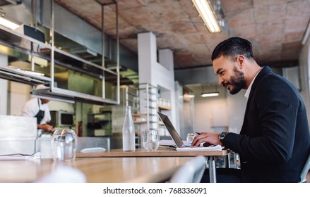 Business Man Sitting At Restaurant Working On Laptop. Caucasian Businessman At Restaurant Using Laptop Computer.