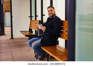 Business man sitting at the train or bus station waiting for his transportation, he's going on vocation - Powered by Shutterstock