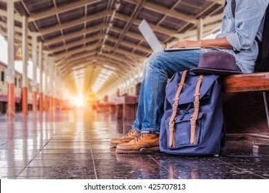 Business Man Sitting With Using Laptop. Travel Bag At The Train Station.vintage Filter Effected. Side View.