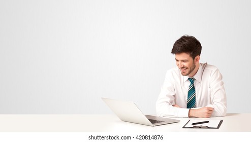 Business Man Sitting At White Table With A White Laptop On White Background