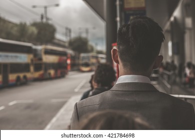 Business Man Standing In A Queue At Bus Stop, View From The Back. Bus Terminal Near International Airport In Hong Kong, China.