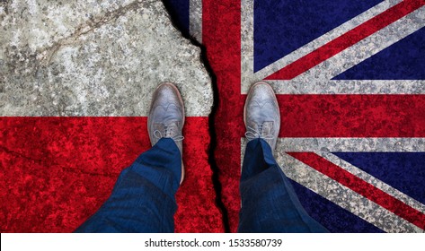 Business Man Stands On Cracked Flag Of UK And Poland. Political Concept