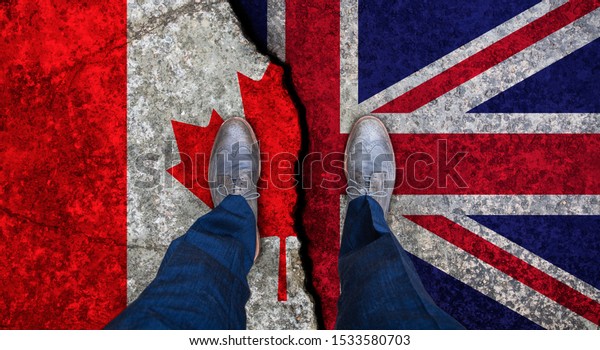 Business man stands on cracked flag of UK and\
Canada. Political\
concept