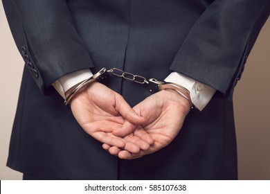 Business Man In A Suit With Handcuffs, Under Arrest For Corruption And Bribery. Selective Focus