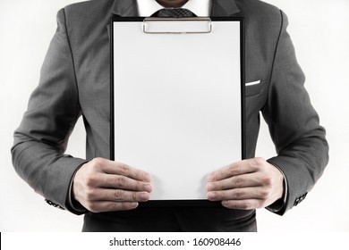 Business Man In Suit Holding A Blank Clipboard. Isolated On White