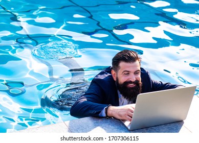 Business man in suit with laptop on swimming pool. Funny businessman relaxing with laptop - Powered by Shutterstock