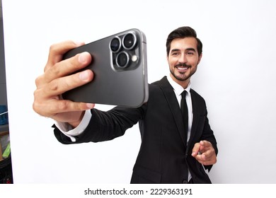 Business man takes selfies on phone with smile with teeth in business suit on white isolated background close-up on wide-angle lens 