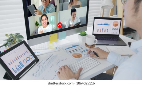 Business Man Talking About Sale Report In Video Conference.Asian Team Using Laptop And Tablet Online Meeting In Video Call.Working From Home, Working Remotely And Self Isolation At Home