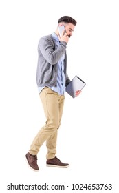 Business Man Talking On The Phone Walking And Carrying Tablet Computer Looking Down. Full Body Length Portrait Isolated On White Studio Background.