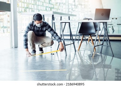 Business Man Tape Being Attached Behind Social Distancing Signage On Office Floor During COVID-19 Pandemic . Social Distancing Concept.