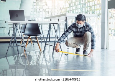 Business Man Tape Being Attached Behind Social Distancing Signage On Office Floor During COVID-19 Pandemic . Social Distancing Concept.