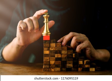 business man try to build wood block on wooden table and blur background business organization startup concept