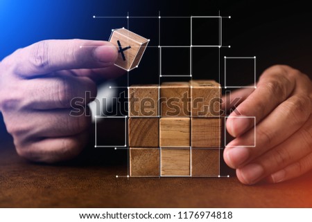 business man try to build wood block on wooden table and blur background business organization startup concept